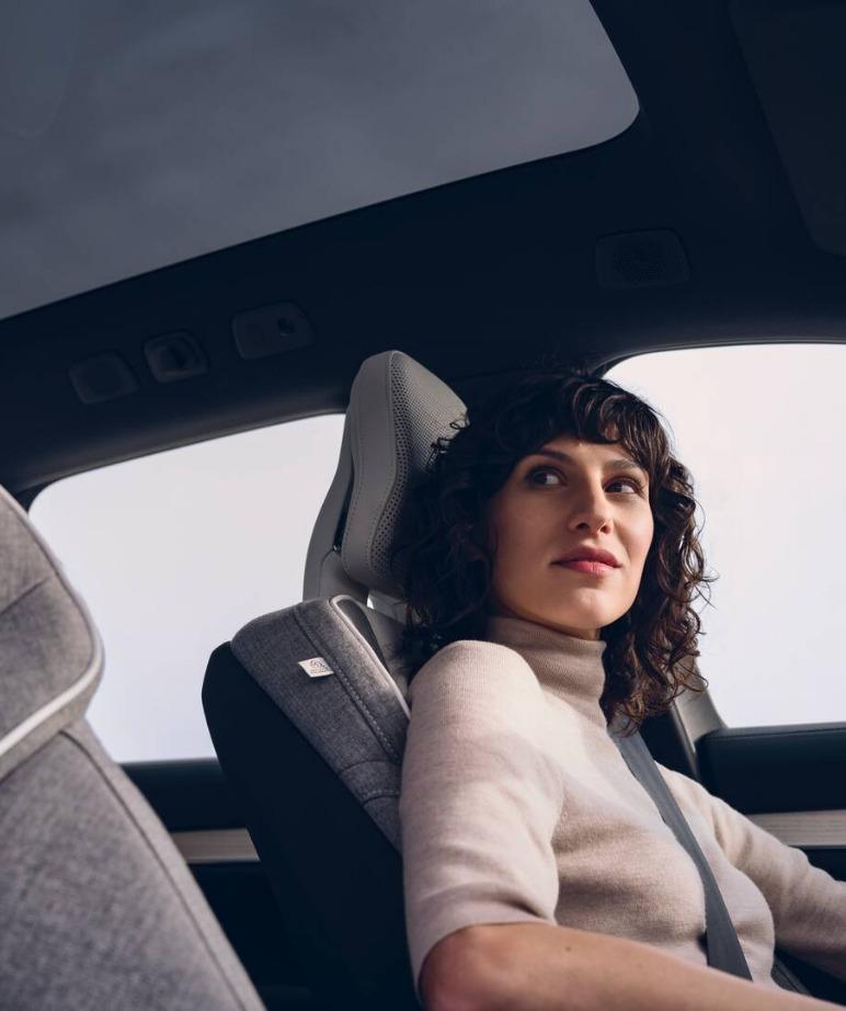 Mujer conduciendo un Volvo, vista interior del vehículo, acabados de alta calidad.